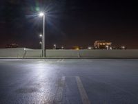 empty parking lot with city lights over the city skyline in the background at night time