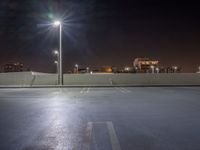 empty parking lot with city lights over the city skyline in the background at night time