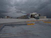 a parking lot with concrete walls with cars parked on the curb and a building in the background