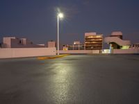 the parking lot is empty of people or vehicles at night time, with street lights on