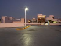 the parking lot is empty of people or vehicles at night time, with street lights on