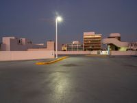 the parking lot is empty of people or vehicles at night time, with street lights on