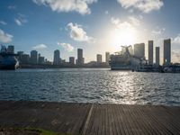 the view of a city in the sun with some palm trees next to the boardwalk