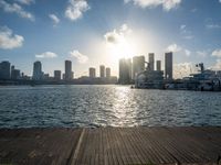 the view of a city in the sun with some palm trees next to the boardwalk