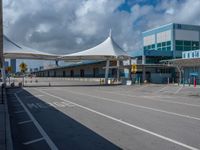 a bus stop with an awning is at the airport terminal and a blue and green building