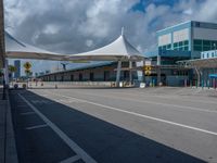 a bus stop with an awning is at the airport terminal and a blue and green building