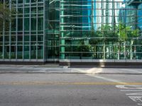 the street with no traffic and buildings behind it is empty, clear with the glass walls