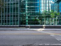 the street with no traffic and buildings behind it is empty, clear with the glass walls