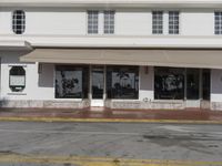 the facade of a building with a storefront and an entrance has white doors with many windows