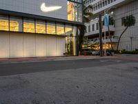 the exterior of a business building is lit up in yellow and purple light in the dusk