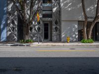 a building with some trees and a yellow fire hydrant on it's side