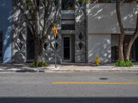 a building with some trees and a yellow fire hydrant on it's side