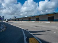 an empty lot with an empty parking lot in the background and clouds in the distance