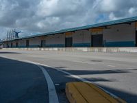 an empty lot with an empty parking lot in the background and clouds in the distance