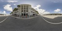 a 360 - view of a street and the ocean in the background and clouds over the buildings