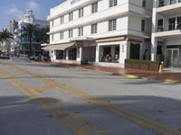 this is the sidewalk at a shopping mall that has cars going by it and buildings to the side