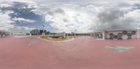 there is a large skateboard park at the city's edge as clouds cover the sky