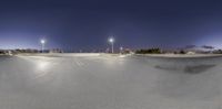 a skateboard ramp with a city in the background on a clear day at night