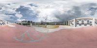 a skateboarder is in the middle of a ramp on a ramp with a building and cloudy sky in the background