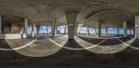 an empty room has three circles with some pillars and a blue sky in the background