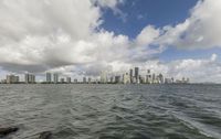 a view of a large city on the ocean and buildings on a cloudy day from the water