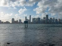 a city skyline seen from the water with a few boats in it at anchor in a body of water