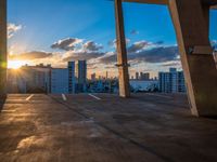 a city skyline is in the distance as the sun sets over the buildings that overlook the beach