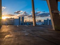 a city skyline is in the distance as the sun sets over the buildings that overlook the beach