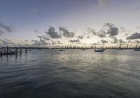 a view of the sky, with many boats and some docks in it at sunrise