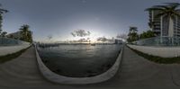 a photo taken on a fish eye lens looking towards the ocean with skyscrapers in the background