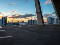 a man on a skateboard in an urban setting, with the sun setting over the city