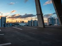 a man on a skateboard in an urban setting, with the sun setting over the city