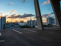 a man on a skateboard in an urban setting, with the sun setting over the city