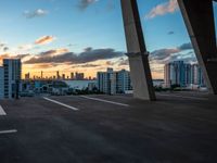 a man on a skateboard in an urban setting, with the sun setting over the city