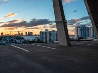 a man on a skateboard in an urban setting, with the sun setting over the city