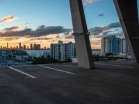 a man on a skateboard in an urban setting, with the sun setting over the city