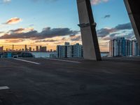 a man on a skateboard in an urban setting, with the sun setting over the city