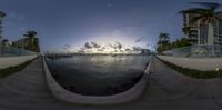 the panorama photo is showing the city and lake side of a park and the sun is set