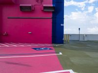 a pink building has an air conditioning unit inside of it's doorway, on a sidewalk