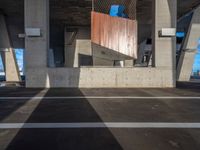 a skateboarder performing a trick in a parking garage, on the edge of an overpass