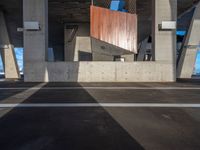 a skateboarder performing a trick in a parking garage, on the edge of an overpass