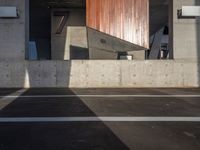 a skateboarder performing a trick in a parking garage, on the edge of an overpass