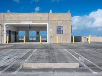 a parking garage with several parking gates in a lot with blue sky and cloud cover