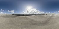 a 360 view of the sky, clouds and cityscape in the background on the street