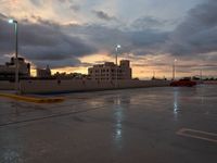 a red truck is parked in the rain at sunset on a street with no cars