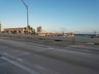 an expressway highway with cars travelling down the freeway and palm trees in the distance with buildings and buildings behind them