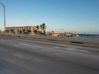 an expressway highway with cars travelling down the freeway and palm trees in the distance with buildings and buildings behind them