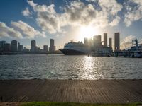 the view of a city in the sun with some palm trees next to the boardwalk