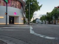 a street view with traffic lights, the building is white, and the sign says love