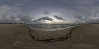 an image of the sun setting on a beach through a fish eye lense photo